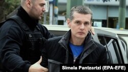 Görög rendőrök viszik az orosz állampolgárságú Vinnyiket a bíróságra Athénban. 2018. december 19.