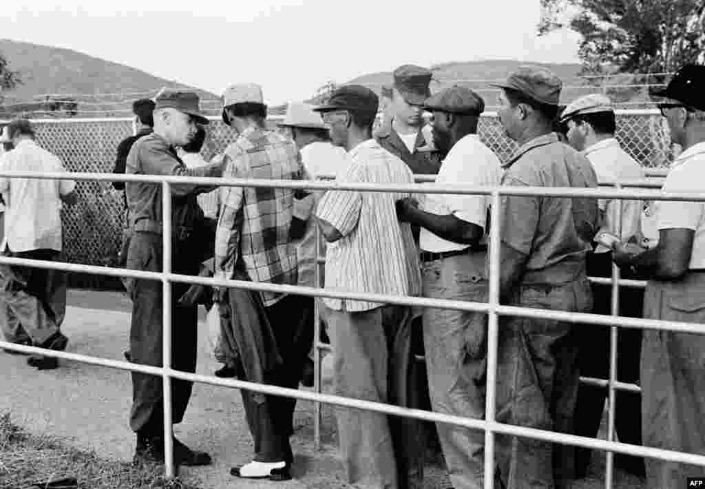 U.S. forces also reinforced measures to protect the American naval base at Guantanamo Bay, Cuba. Here, soldiers check Cuban nationals leaving the facility in late November 1962.