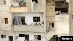 Copii la balconul unei clădiri în Siria