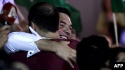 Лидер коалиции СИРИЗА Ципрас обнимает сторонников в избирательном штабе. 20 сентября 2015 года.