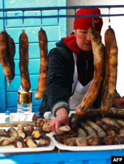 A Kyrgyz vendor sells sausages prepared from horse meat at Bishkek's Osh Bazaar. (file photo)