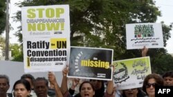 FILE: Pakistani human rights activists carry placards and banners during a protest for missing persons to mark the International Day of the Victims of Enforced Disappearances in Karachi.
