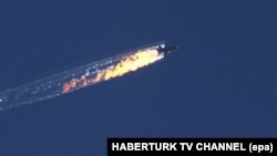 Turkey -- A still image made available on 24 November 2015 from video footage shown by the HaberTurk TV Channel shows a burning trail as a plane comes down after being shot down near the Turkish-Syrian border, over north Syria, 24 November 2015.