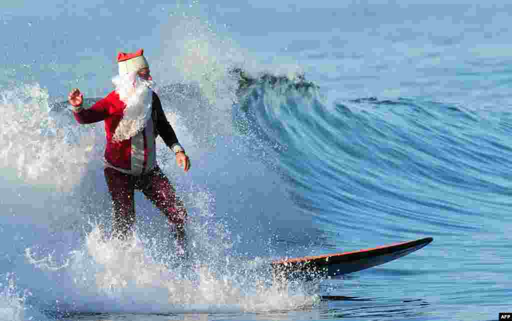 Surfing Santa Michael Pless, 61, catches a wave at Seal Beach, south of Los Angeles on December 24. (AFP/Frederic J. Brown)