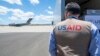 A USAID employee watches a U.S. Air Force plane preparing to deliver coronavirus aid to Russia last year.