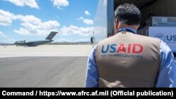 A USAID employee watches a U.S. Air Force plane preparing to deliver coronavirus aid to Russia last year.