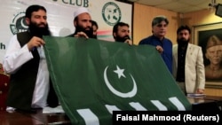 FILE: Saifullah Khalid (2nd L), President of Milli Muslim League (MML) political party, holds a party flag with others during a news conference in Islamabad, August 2017