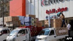 Iraqi men unload air conditioners and electrical appliances imported from Iran in Baghdad on February 23, 2019. (Photo by SABAH ARAR / AFP)