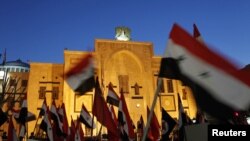 Syrian activists wave flags during a sit-in protest outside the parliament building in Damascus on February 21.