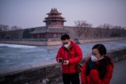 شهروندان در نزدیک شهر ممنوعه در پکن؛ فرارسیدن تعطیلات سال نوی چینی بر نگرانی‌ها از شیوع ویروس افزوده است