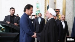 حسن روحانی رئیس جمهوری ایران (راست) حین مصافحه با عمران خان صدراعظم پاکستان در تهران. October 13, 2019