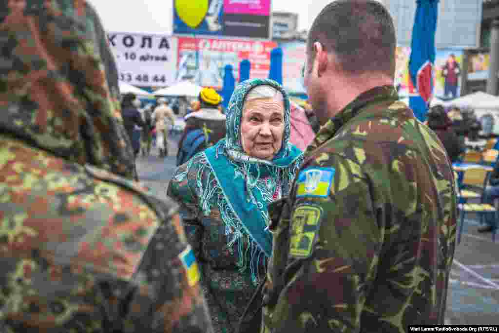 Літня жінка вітає військових зі святом