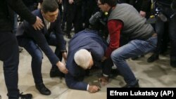 Serhiy Syvokho, an adviser to the secretary of the National Security and Defense Council, is helped up after he was push to the floor by a right-wing activist in Kyiv on March 12.