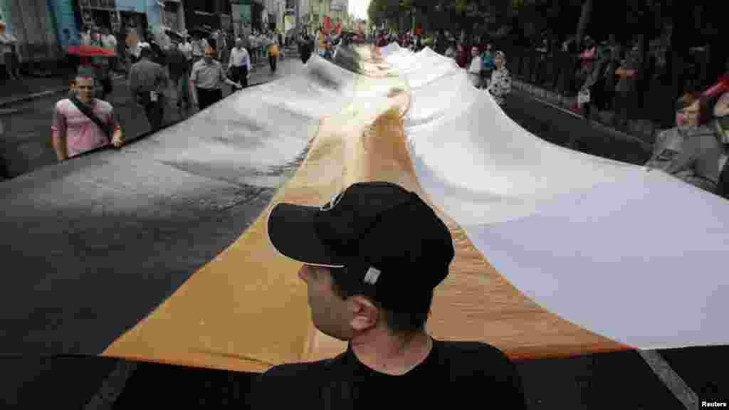 Russian activists hold a huge imperial-era flag during an antigovernment protest in Moscow on June 12. (Reuters/Sergei Karpukhin)