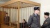 Belarus -- Former opposition campaigner Vasil Parfyankau sits in a cage guarded by the police in a court room in Minsk, 17Feb2011