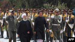 Iranian President Hassan Rohani (left) and Pakistani Prime Minister Imran Khan reviewing an honor guard in Tehran on April 22