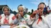 Belarusian women in traditional dress drink vodka in the village of Plastok, south of Minsk, during the Orthodox celebration of Trinity Sunday.
<br /><br />Photo by Victor Drachev for AFP