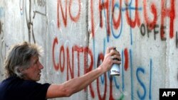 Roger Waters, co-founder of the rock group Pink Floyd, paints graffiti on a visit to Israel.
