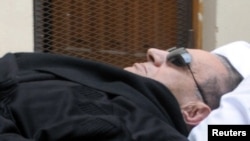 Former Egyptian President Hosni Mubarak lies on a stretcher as he is wheeled into the courtroom in Cairo on January 5.