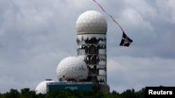 A kite flies near the antennas of a former U.S. National Security Agency Cold War listening post at Teufelsberg hill in Berlin.