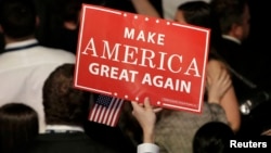 U.S. -- A Trump supporter holds up a campaign sign at Republican U.S. presidential nominee Donald Trump's election night rally in Manhattan, New York, U.S., November 9, 2016