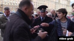 A screen grab of two men being arrested outside the U.S. Embassy in Moscow after they placed a sign at a makeshift shrine to the victims of a mass shooting in a gay nightclub in Florida. 