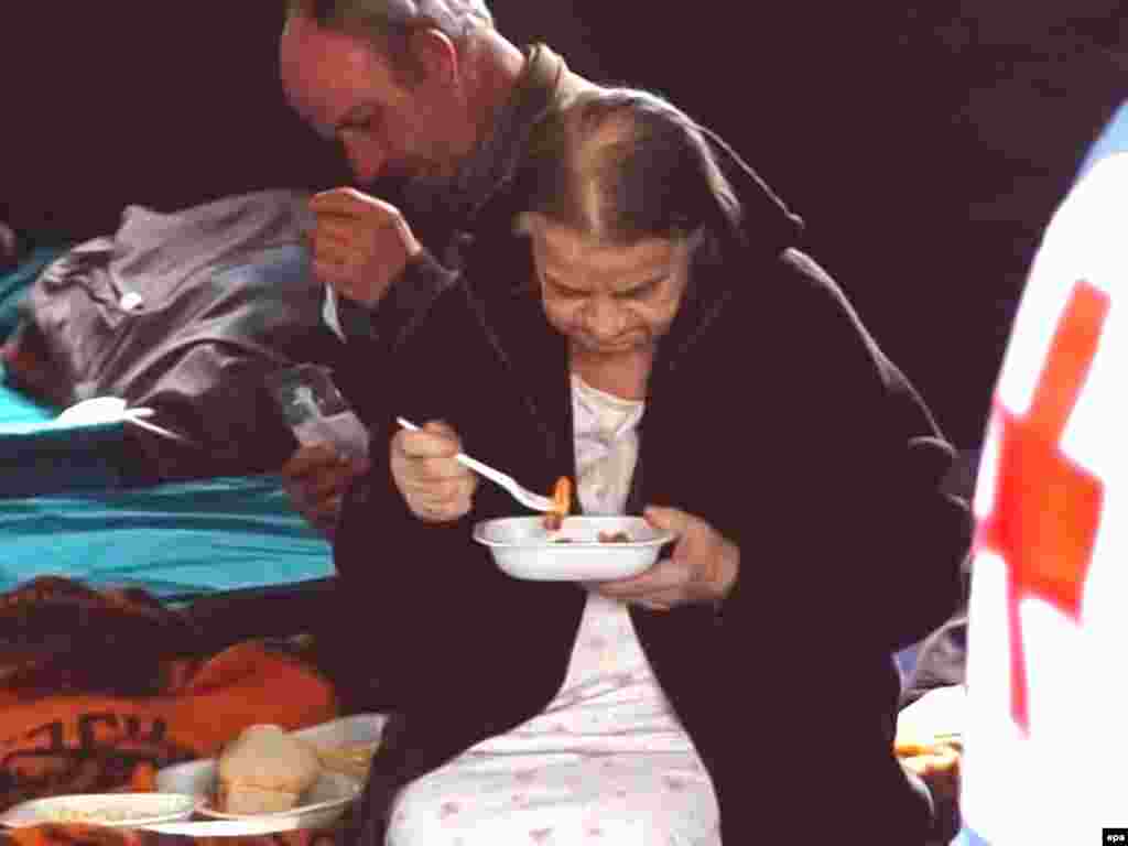 Italy - Earthquake victims receive lunch in a tent camp in L'Aquila, 07Apr2009 - Caption: epa01690824 Earthquake victims receive lunch in a tent camp in L'Aquila, central Italy, 07 April 2009. The death toll from an earthquake that struck central Italy on 06 April 2009 has risen to 179, according to the coordinating centre for rescue services from the battered town of L'Aquila. Of the dead, 40 bodies still need to be identified. An additional 34 people are still missing more than 24 hours after the earthquake, which registered between 5.8 and 6.2 on the Richter scale. EPA/MASSIMILIANO SCHIAZZA 