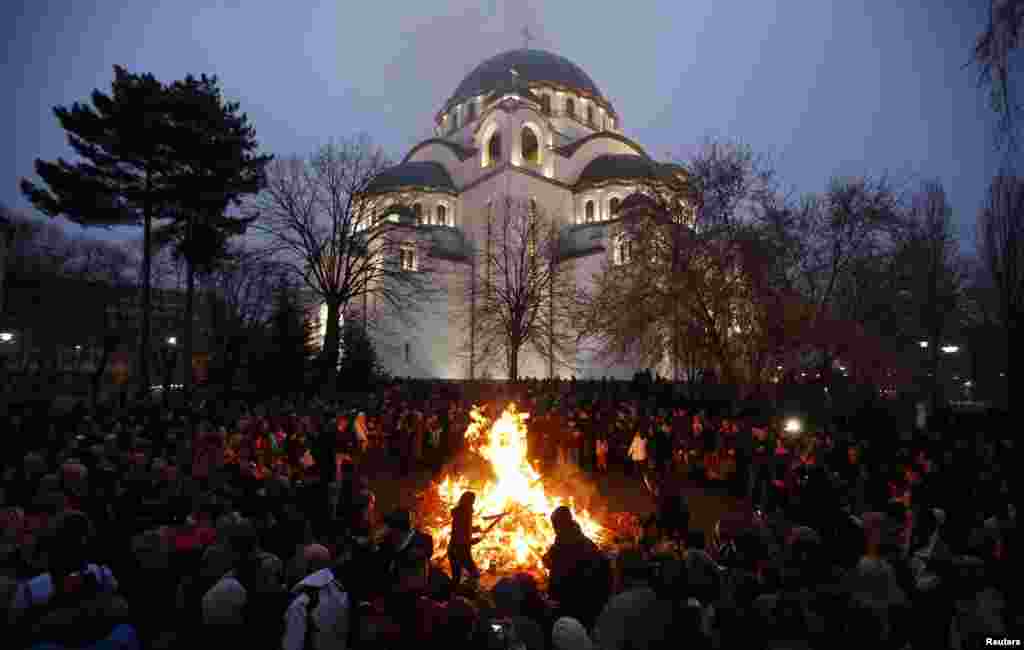 In Serbia, believers burn dried oak branches, which symbolize the Yule log, on Orthodox Christmas Eve in front of the St. Sava temple in Belgrade.