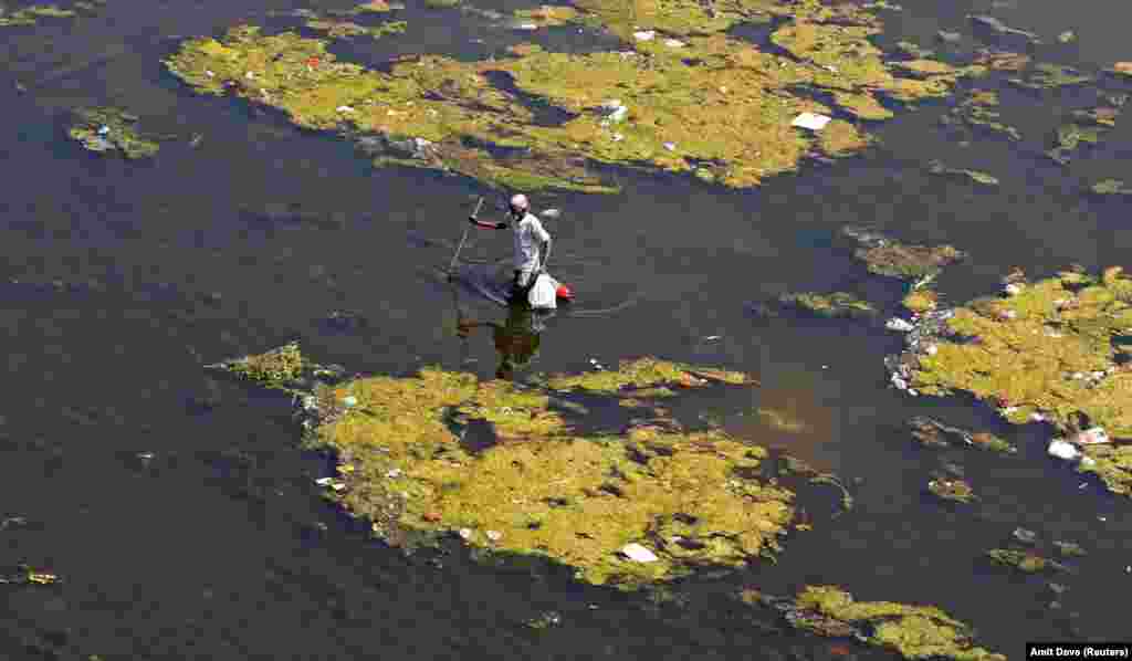 A man looks for recyclable items in the polluted waters of the Sabarmati River, ahead of World Water Day, in Ahmedabad, India, on March 21. (Reuters/Amit Dave)