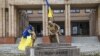 Ukrainian flags are displayed on a statue of Taras Shevchenko in the center of the city of Balaklia in the Kharkiv region after it was liberated from Russian forces.