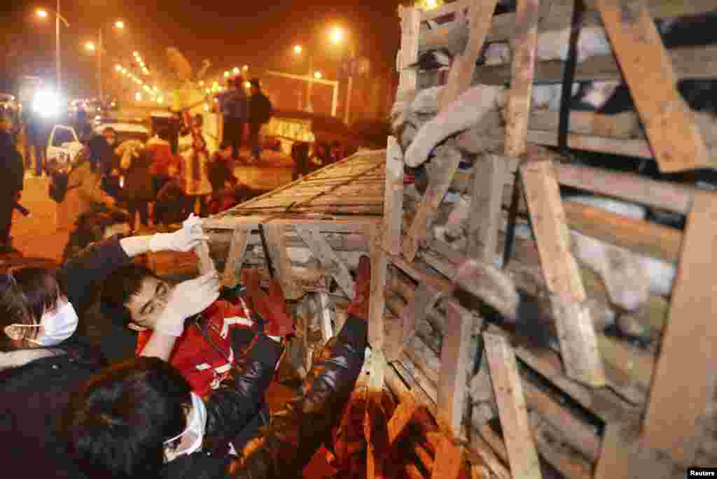 Volunteers try to save cats locked in cages without food and water after a traffic accident on a street in Changsha in China's Hunan Province. A truck carrying more than 1,000 cats to Guangdong to sell them to diners was involved in a traffic accident. Around 50 animal protection group members and volunteers rescued the cats after they heard the news and later sent the cats to a clinic for treatment. (Reuters/China Daily)