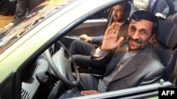 Iranian President Mahmud Ahmadinejad waves to the press as he sits in a car during an inaugural ceremony for Saipa group's All-Iranian Automobile production line, Miniator, in Tehran in December 2008.
