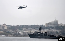 Российский военный вертолет кружит над портом в Севастополе.