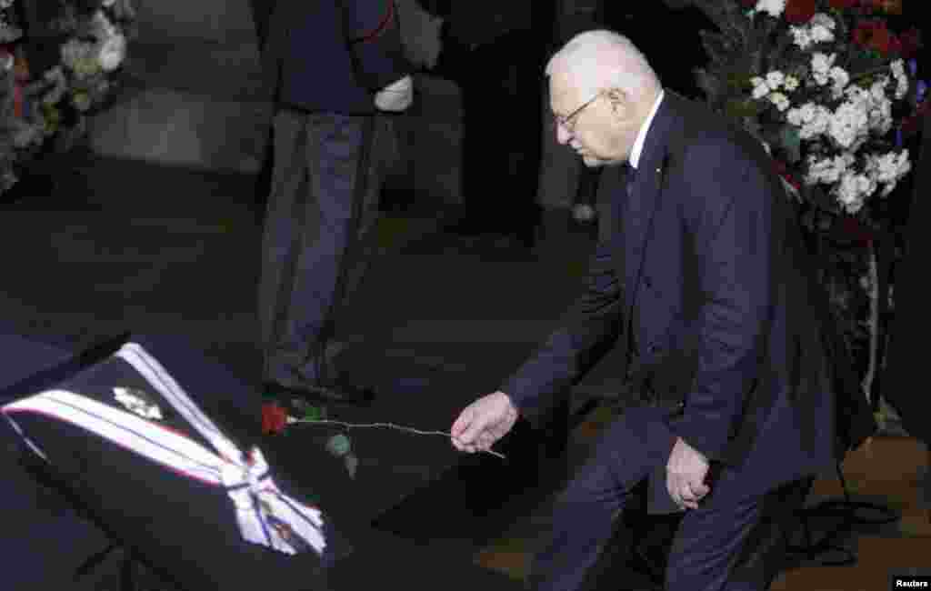 Current Czech President and Havel&#39;s longstanding political rival Vaclav Klaus places a flower in front of the late leader&#39;s coffin inside Prague Castle. 