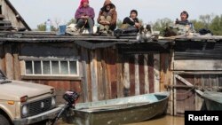 Местные жители спасаются от паводка на крышах домов
