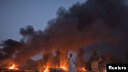 A local resident watches fuel tankers burn along the GT road in Nowshera, Khyber-Pakhtunkhwa Province, on October 7.