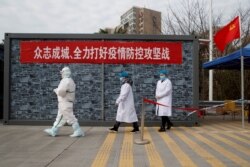 Китай, місто Цзюцзян: медики в захсному спорядженні чергують на КПП на мості, що веде через річку Янцзи в закриту на карантин частину сусідньої провінції Хубей, яка стала осередком поширення нової хвороби, 1 лютого 2020 року