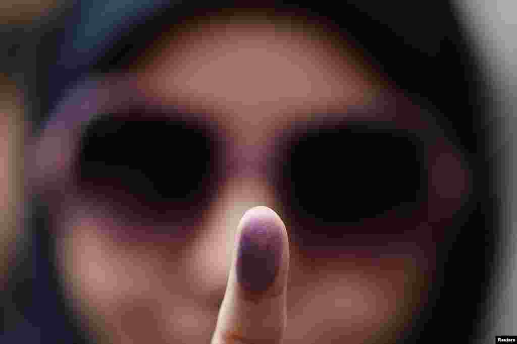 Voter Zeynab shows the ink stain on her finger, to prove that she has voted, outside the Iranian Consulate in central London. (Reuters/Stefan Wermuth)