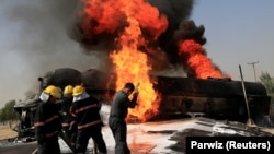 Afghan firefighters attempt to extinguish a burning fuel tanker which was hit by a magnetic bomb on the outskirts of the eastern city of Jalalabad on October 16.