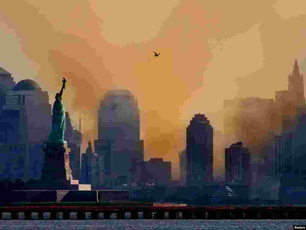 Smoke from the remains of New York's World Trade Center shrouds lower Manhattan as a lone seagull flies overhead in a photograph taken across New York Harbor from Jersey City, New Jersey September 12, 2001. Each of the twin towers were hit by hijacked airliners and collapsed in one of numerous acts of terrorism directed at the United States on September 11, 2001. REUTERS/Ray Stubblebine 