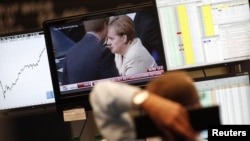 A trader at the Frankfurt stock exchange watches a news broadcast showing German Chancellor Angela Merkel. (file photo)