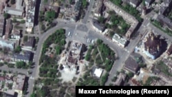 Драмтеатр в Маріуполі після бомбового удару армії России, що був здійснений 16 березня 2022 року, в укритті якого перебували сотні цивільних, зокрема діти. Маріуполь, 12 травя 2022 року, Супутниковий знімок Maxar Technologies