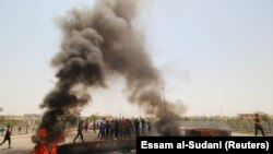 IRAQ -- Iraqi protesters burn tires and block the road at the entrance to the city of Basra, Iraq July 12, 2018. 