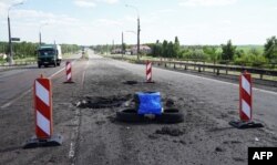 A picture taken on July 21, 2022 shows craters on Kherson's Antonovsky bridge across the Dnipro river caused by a Ukrainian rocket strike, amid the ongoing Russian military action in Ukraine. Kherson, July 21, 2022