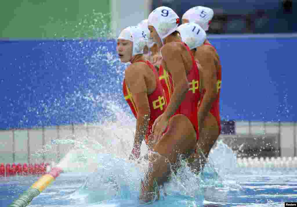 Chinese players jump during a women&#39;s water polo match against Hungary.