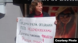 Наталья Цымбалова, координатор «Альянса гетеросексуалов за равенство ЛГБТ», проводит одиночный пикет против "антигомосексуального" закона.