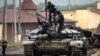 Ukrainian police officers take a selfie on a destroyed Russian tank in the liberated town of Izyum in the Kharkiv region on September 14.