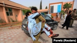 FILE: An injured man is carried to a hospital after a car bomb in Jalalabad on June 17