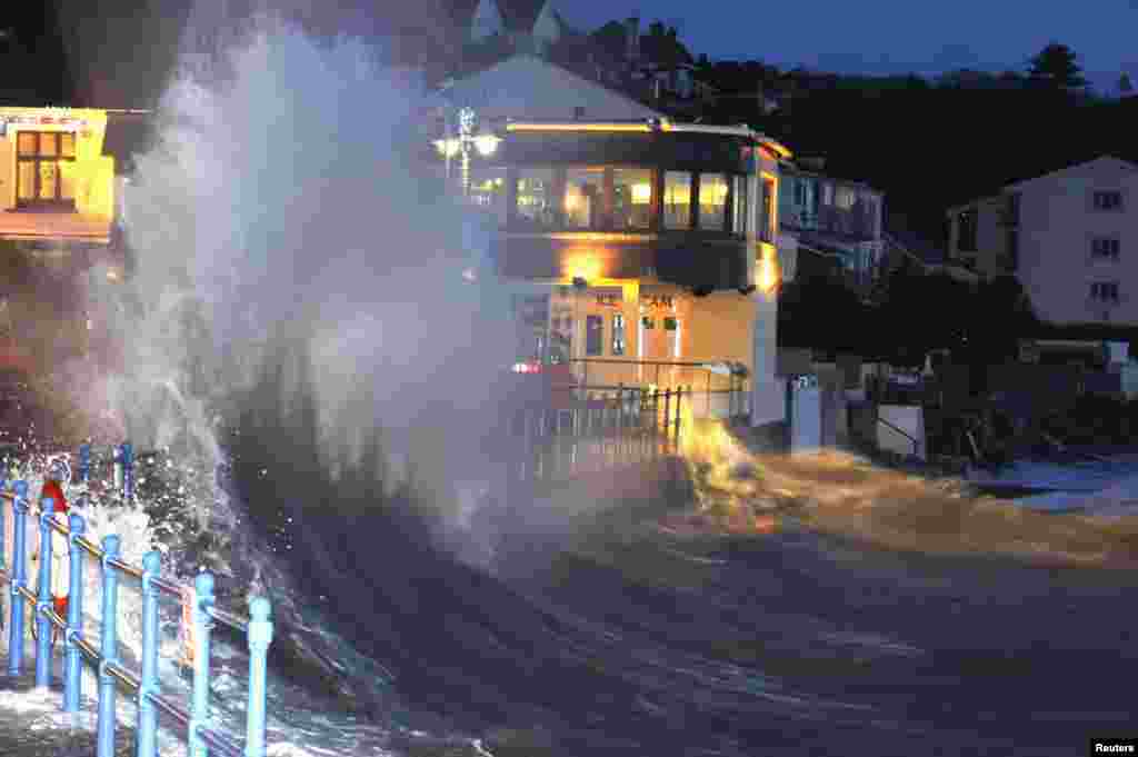 Waves crash over the promenade at hightide in Saundersfoot, in west Wales. (Reuters/Rebecca Naden)