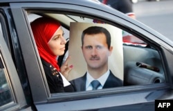 Сирия президенті Башар Асадты қолдайтын әйел оның суретін ұстап отыр. Дамаск, 11 қыркүйек 2013 жыл.